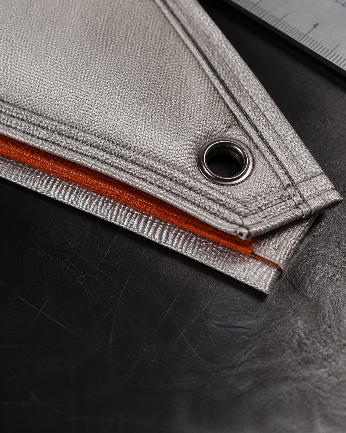Precision stitched fiberglass blanket corner with reinforced eyelet